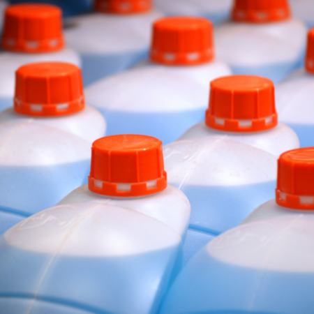 Close up of commercially package blue liquid solution with red cap.