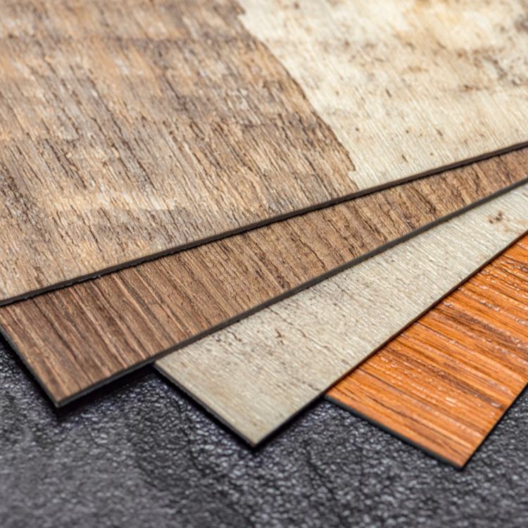 A close up of manufactured flooring samples that resemble wood grain.