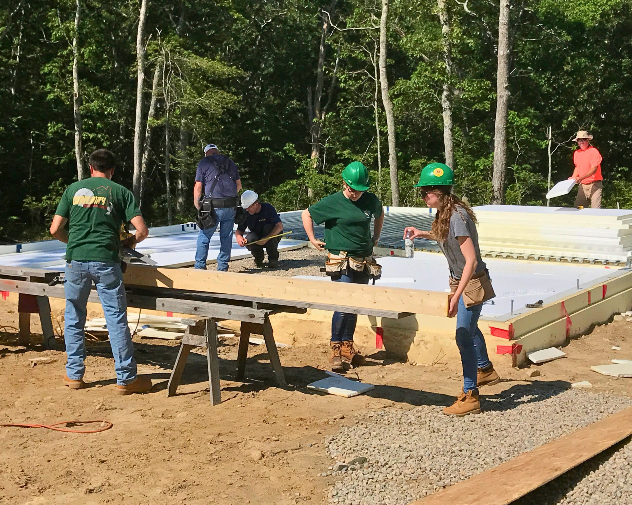 Students from Greater New Bedford Vocational Technical High School work on the foundation of the Lloyd Center Welcome Center