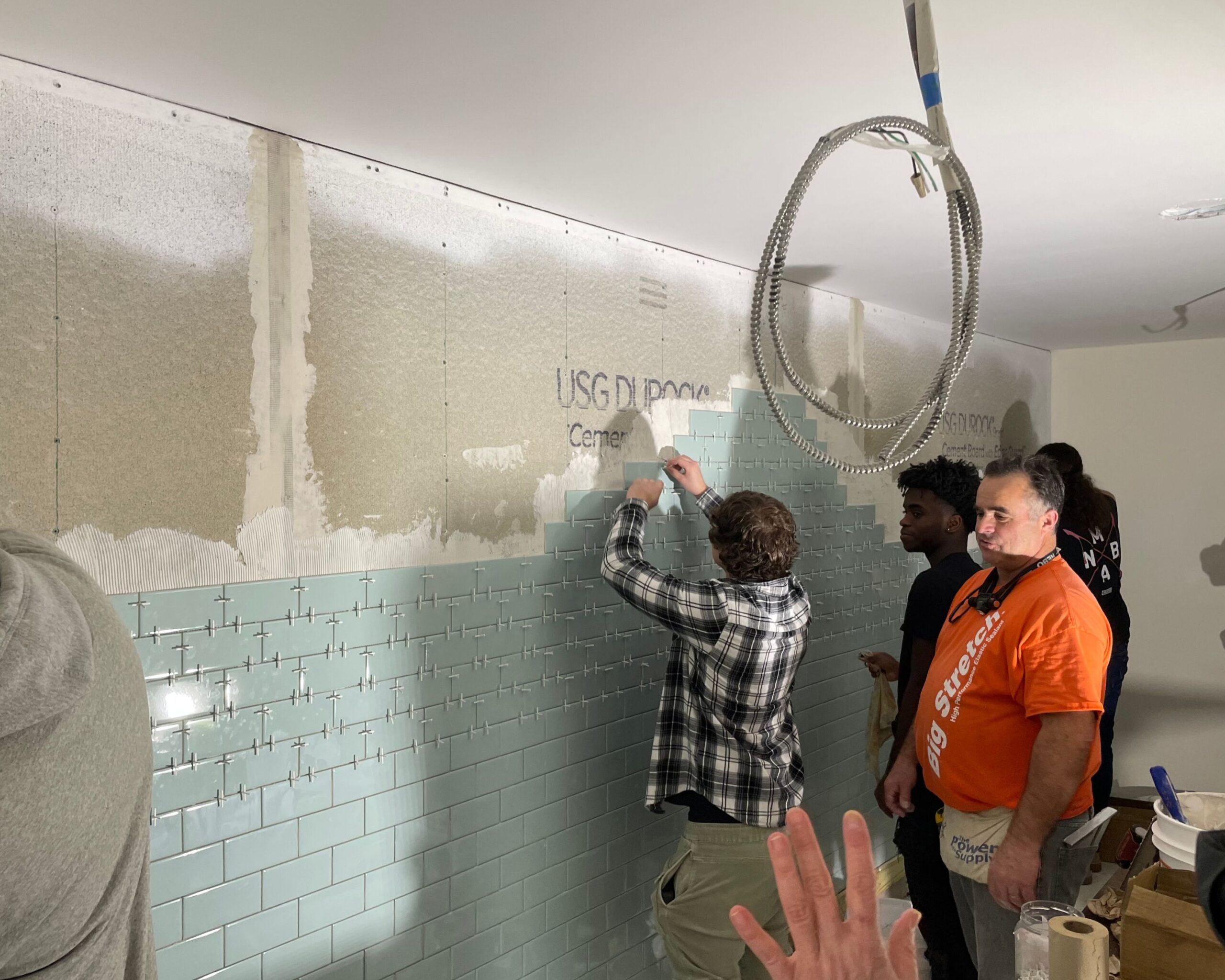Students from Greater New Bedford Vocational Technical High School tile tan interior room of the Lloyd Center Welcome Center