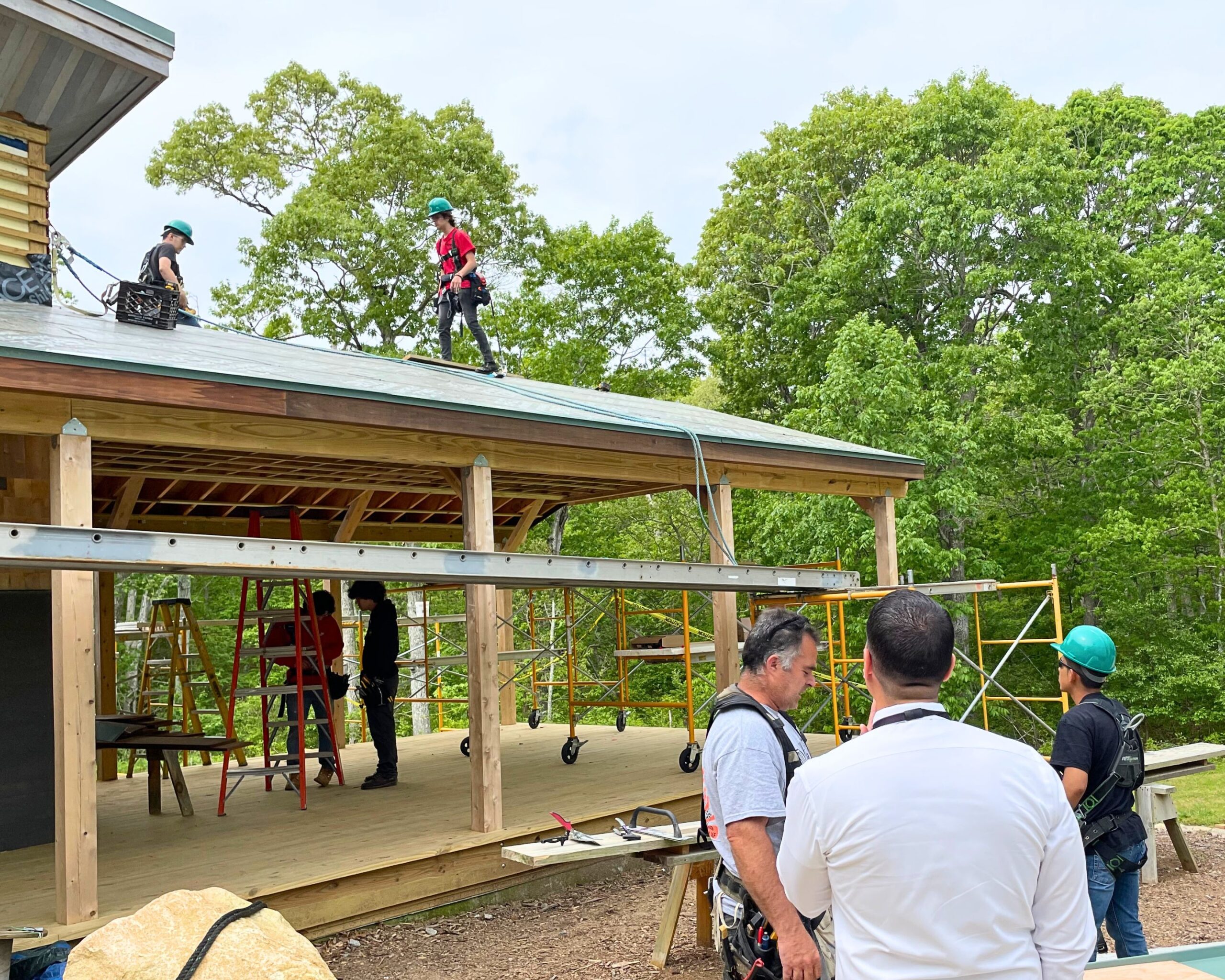 Students and instructors from Greater New Bedford Vocational Technical High School work on the roofing on the Lloyd Center Welcome Center