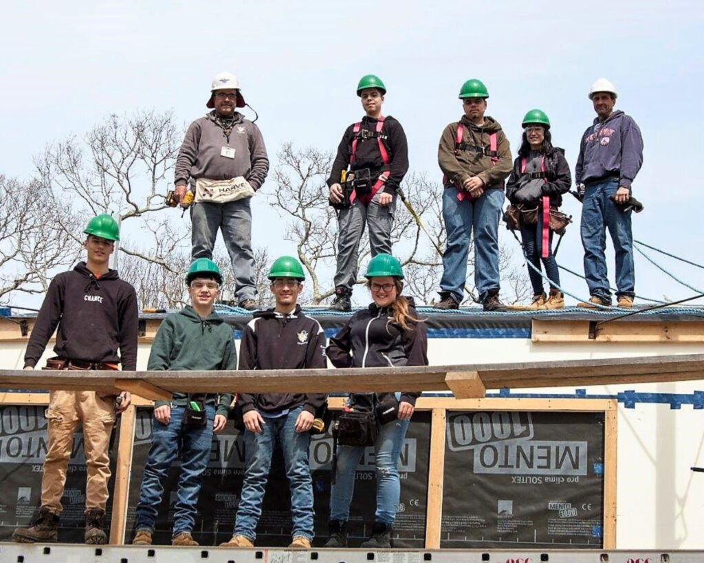Students from Greater New Bedford Vocational Technical High School pause for a photo while working on building wrap and roofing on the Lloyd Center Welcome Center